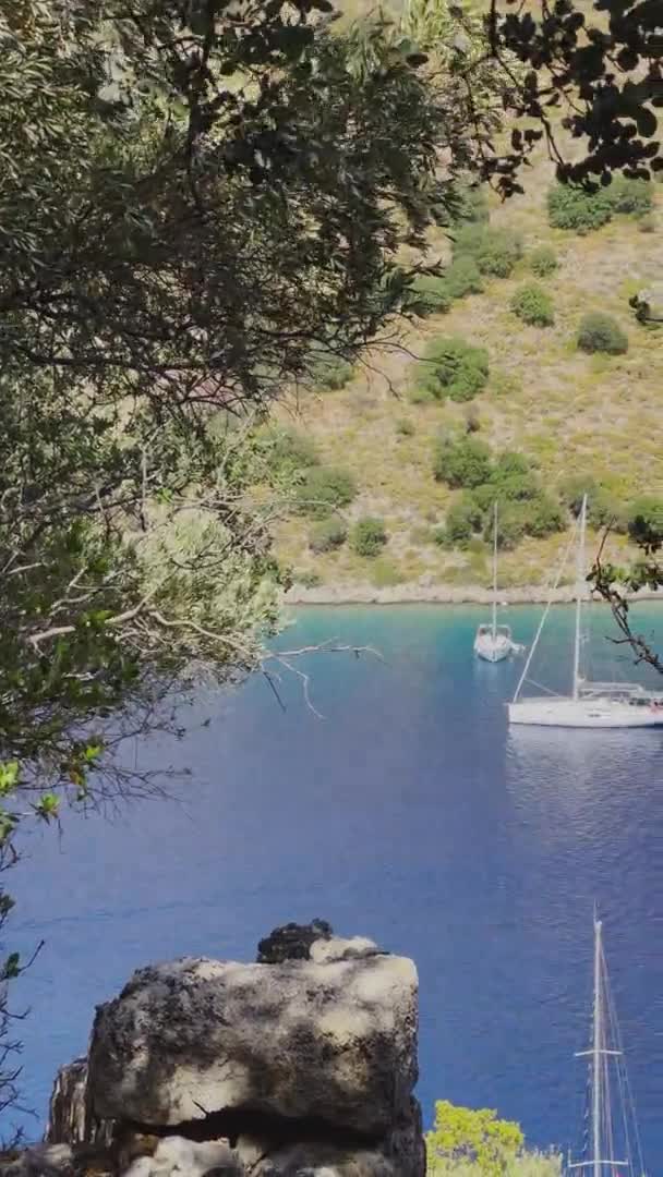 Nagranie pionowe malowniczej zatoki w pobliżu wyspy Gemiler, samotna żaglówka na morzu, wyspy w pobliżu Marmaris, regaty żaglowe, góry na tle, widok z góry w pogodę — Wideo stockowe