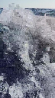 Kayığın arkasındaki berrak deniz suyunun dikey görüntüsü ufuk görünür, güneşte bir sürü köpük ve köpük parıltısı var.