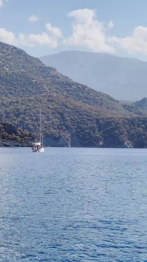 Turkiet, Sarsala, 03 oktober 2021: Den pittoreska bukten Gemiler ön, skeppare flicka för första gången kör en segelbåt, nära Marmaris, segling regatta, berg på bakgrunden — Stockvideo