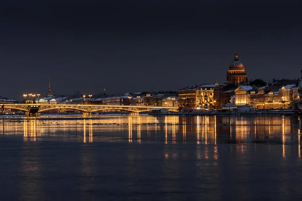 Панорамные кадры зимнего ночного города Санкт-Петербург с живописным отражением на воде, Исаакиевский собор на заднем плане, Благовещенский мост, старое имя лейтенант Шмидт — стоковое фото