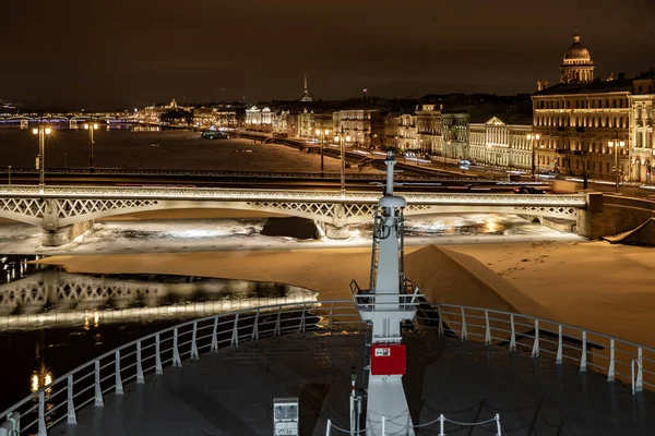 Nagranie panoramiczne zimowej nocy miasta Sankt-Petersburg z malowniczą refleksją na temat wody, duży statek zacumowany w pobliżu mostu Blagoveshchensky lub porucznik Schmidt, katedra Isaac na tle — Zdjęcie stockowe