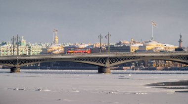 Saint-Petersburg kışının panoramik manzarası, donmuş Neva nehri, Blagoveshchensky Köprüsü 'ndeki kırmızı turistik otobüs, Kış Sarayı, Deniz Kuvvetleri binası, arka plandaki Alexander sütunu.