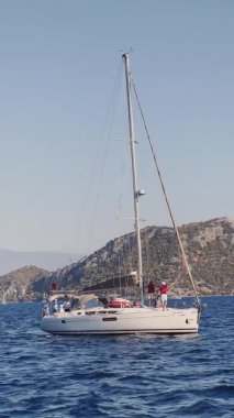 Türkiye, Fethiye, 03 Ekim 2021: Marmaris yakınlarındaki birçok adadan biri olan Sarsala 'nın pitoresk körfezi, gemideki yelkenli yarışlarına katılanlar, arka plandaki dağlar