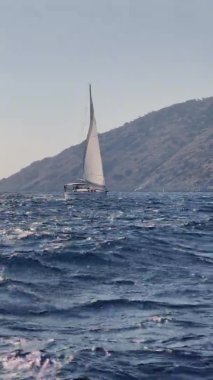 Marmaris yakınlarındaki pek çok adanın yakınlarındaki pitoresk deniz manzarası, gemideki yelkenli yarışlarına katılanlar, arka plandaki dağlar.