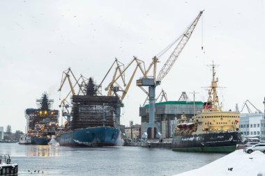 Rusya, St. Petersburg, 05 Şubat 2021: Nükleer buz kırıcıların inşası, soğuk bir kış gününde Baltık tersanesinin vinçleri, Neva nehri üzerinde buhar, nehrin pürüzsüz yüzeyi