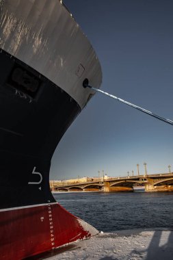 Güneşli bir günde Saint-Petersburg 'un panoramik manzarası, Blagoveshchensky köprüsü yakınlarında demirlemiş büyük bir gemi, demirleme hatları, kalın ipler, arka planda nehir ve köprü.