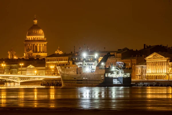 Nagranie panoramiczne zimowej nocy miasta Sankt-Petersburg z malowniczą refleksją na temat wody, duży statek zacumowany w pobliżu mostu Blagoveshchensky lub porucznik Schmidt, katedra Isaac na tle — Zdjęcie stockowe