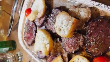 Tabakta homurdanan bir et tabağının dikey videosu, kızarmış ekmek, domates, tereyağından yansıyan ışık.