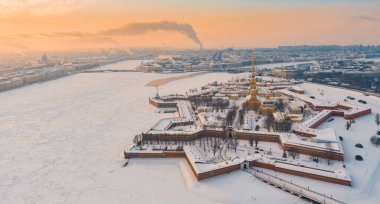 St. Petersburg 'da kış günbatımında Drone bakış açısı, donmuş Neva nehri, şehrin üzerinde buhar, Peter ve Paul kalesi, Trinity köprüsünde araba trafiği, rostral sütunlar, saray asma köprüsü, panoramik manzara