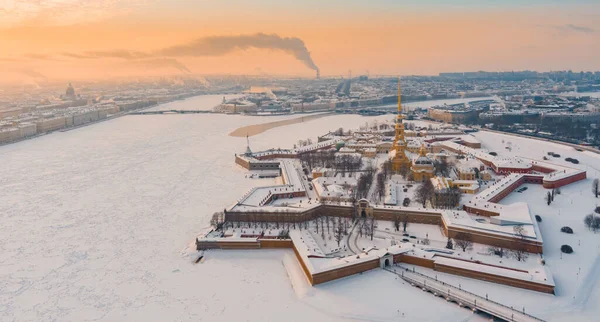 Drone standpunt van de winter St. Petersburg bij zonsondergang, bevroren Neva rivier, stoom over de stad, Peter en Paul fort, autoverkeer op Trinity brug, rostral kolommen, Palace drawbridge, panoramisch uitzicht — Stockfoto
