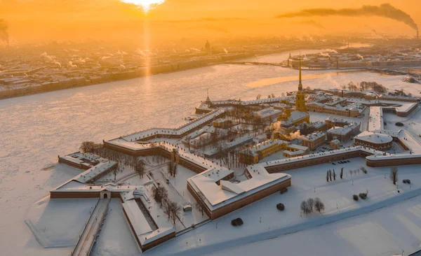 Ponto de vista drone do inverno São Petersburgo ao pôr do sol, rio Neva congelado, vapor sobre a cidade, fortaleza de Peter e Paul, tráfego de carros na ponte Trinity, colunas rostrais, ponte levadiça do palácio, vista panorâmica — Fotografia de Stock