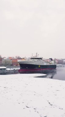 Rusya, St. Petersburg, 07 Aralık 2021: St. Petersburg 'un kar fırtınasındaki kış görüntüsü, donmuş Neva nehri, büyük bir gemi, Isaac Katedrali, Blagoveshenskiy köprüsündeki araba trafiği