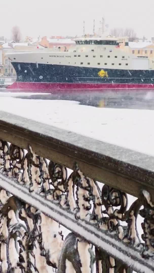ロシア,サンクトペテルブルク, 07 12月2021:雪の嵐でサンクトペテルブルクの冬景色のスローモーション映像,凍結ネヴァ川,巨大な船,アイザック大聖堂, Blagoveshenskiy橋の車のトラフィック — ストック動画