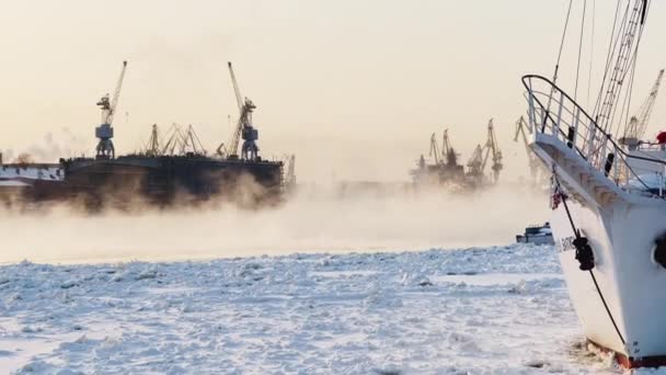 Строительство атомных ледоколов, кранов Балтийской верфи в морозный зимний день, пара над Невой, гладкая поверхность реки — стоковое видео