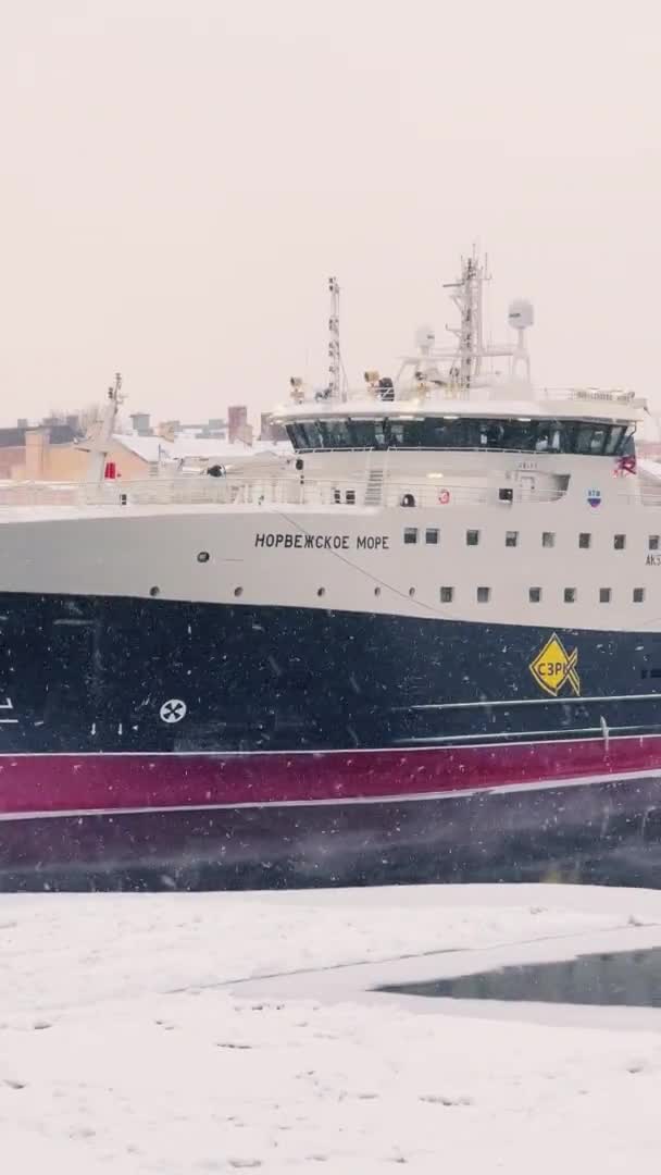 Russia, St. Petersburg, 07 December 2021: Slow motion footage of winter view of St. Petersburg at snow storm, frozen Neva river, huge ship, Isaac cathedral, car traffic on Blagoveshenskiy bridge — Stock Video