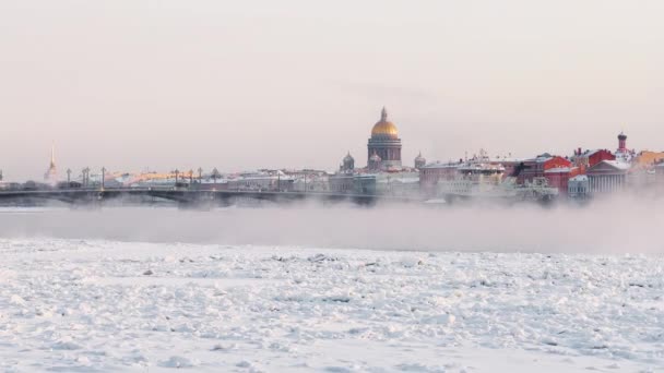 Slow motion footage of winter view of St. Petersburg at sunset, steam over frozen Neva river, huge ship, Isaac cathedral, car traffic on Blagoveshenskiy bridge — Stockvideo