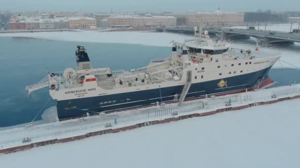 Russia, St. Petersburg, 07 December 2021: Slow motion footage of winter view of St. Petersburg at snow storm, frozen Neva river, huge ship, Isaac cathedral, car traffic on Blagoveshenskiy bridge — Stock Video