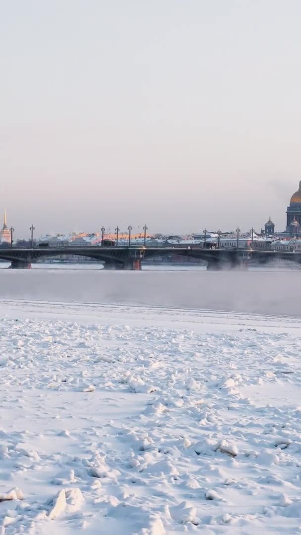 Rusia, San Petersburgo, 07 de diciembre de 2021: Imágenes en cámara lenta de la vista de invierno de San Petersburgo en la tormenta de nieve, el río Neva congelado, barco enorme, la catedral de Isaac, el tráfico de coches en el puente Blagoveshenskiy — Vídeos de Stock