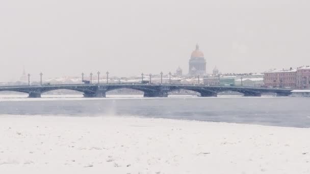 Imagens de câmera lenta da vista de inverno de São Petersburgo na tempestade de neve, rio Neva congelado, vapor sobre a cidade, catedral de Isaac, tráfego de carros na ponte Blagoveshenskiy, ponte levadiça do palácio, vista panorâmica — Vídeo de Stock