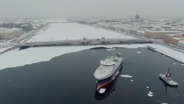 Росія, Санкт-Петербург, 07 грудня 2021 р.: повільні зйомки зимового краєвиду Санкт-Петербурга на сніговій бурі, заморожена річка Нева, величезний корабель, кафедральний собор Ісаака, автомобільний рух на Благовенському мості — стокове відео