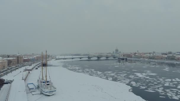 Russia, St. Petersburg, 07 December 2021: Slow motion footage of winter view of St. Petersburg at snow storm, frozen Neva river, steam over city, Isaac cathedral, car traffic on Blagoveshenskiy bridge — 图库视频影像