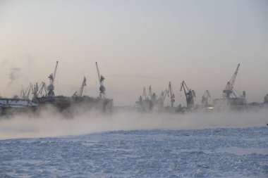 Nükleer buz kırıcıların inşası, soğuk bir kış gününde Baltık tersanesinin vinçleri, Neva nehrinin üzerinde buhar, nehrin pürüzsüz yüzeyi.