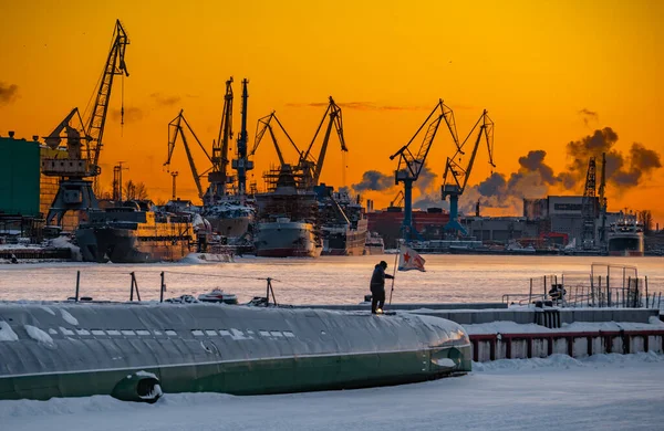 Bau von Atomeisbrechern bei magischem Sonnenuntergang, Kräne der baltischen Werft an einem frostigen Wintertag, Dampf über der Newa, glatte Flussoberfläche, Himmel von oranger Farbe — Stockfoto