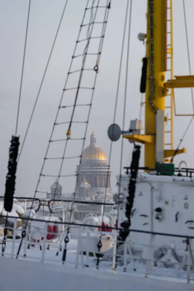 Isaac Katedrali 'nin altın kubbesi St. Petersburg' un soğuk bir günde demirlemiş eski yelkenli teknesinin içinden geçiyor. — Stok fotoğraf