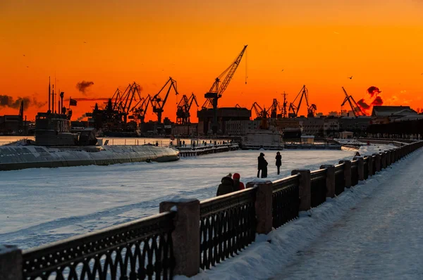 The construction of nuclear icebreakers at magic sunset, cranes of of the Baltic shipyard in a frosty winter day, steam over the Neva river, smooth surface of the river, sky of orange color — Fotografia de Stock