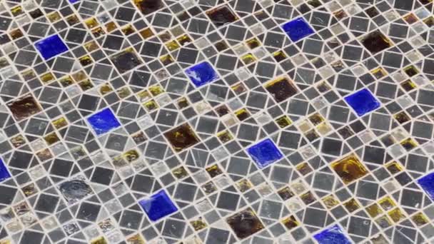 Abstract video of beautiful multi-colored mosaic as a floor covering, reflection of light on a glossy coating, elements of blue, white and amber colors — Stockvideo