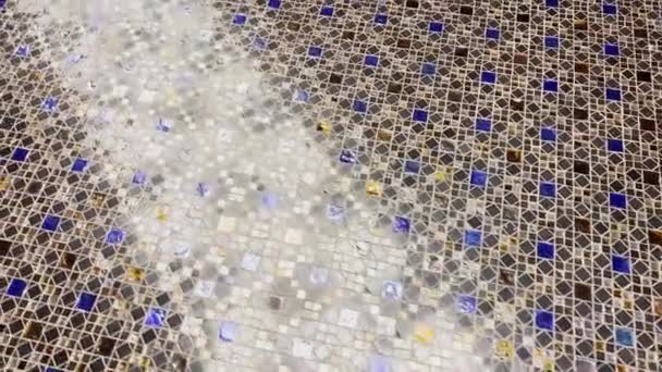 Vidéo abstraite de belle mosaïque multicolore comme revêtement de sol, réflexion de la lumière sur un revêtement brillant, éléments de couleurs bleu, blanc et ambre — Video