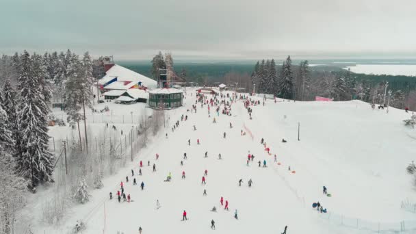 Drone view on cable way in ski resort. Ski lift elevator transporting skiers and snowboarders on snowy winter slope at mountain at weekend, drone flying over snowy slope — Video Stock