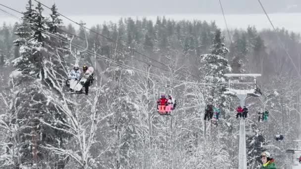 Russia, St. Petersburg, 06 January 2022: Cable way in ski resort. Ski lift elevator transporting skiers and snowboarders on snowy winter slope at mountain at weekend — стокове відео