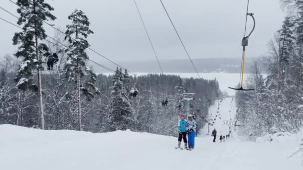 Russia, St. Petersburg, 06 January 2022: Cable way in ski resort. Ski lift elevator transporting skiers and snowboarders on snowy winter slope at mountain at weekend