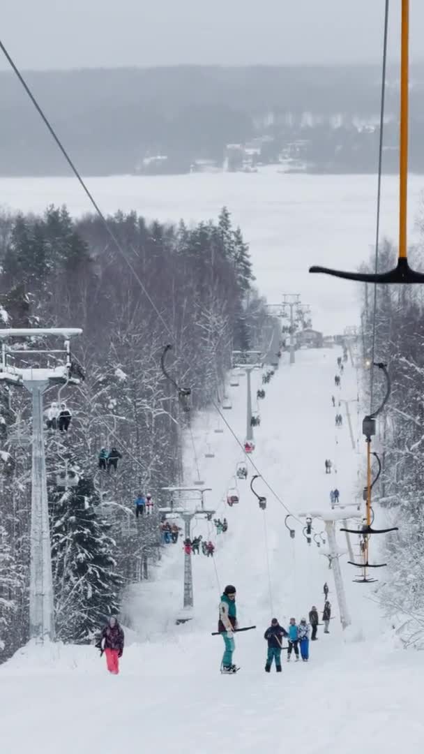 Russia, St. Petersburg, 06 January 2022: Cable way in ski resort. Ski lift elevator transporting skiers and snowboarders on snowy winter slope at mountain at weekend — Video Stock