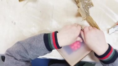 Childrens hands disassemble the mold of rubber, the matrix for making plastic products, construction tools are on the table