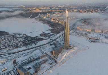 Russia, St. Petersburg, 08 January 2022: Lakhta center skyscraper in a winter frosty evening at sunset, the future main building of the office of the oil company Gazprom, buildings of pink color