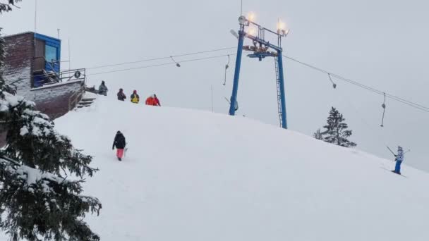Rusia, San Petersburgo, 06 de enero de 2022: Teleférico en la estación de esquí. Remonte elevador de esquí que transporta esquiadores y snowboarders en la pista de invierno nevada en la montaña en fin de semana — Vídeos de Stock