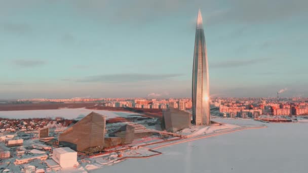 Russie, Saint-Pétersbourg, 08 janvier 2022 : gratte-ciel du centre de Lakhta dans une soirée hivernale givrée au coucher du soleil, le futur bâtiment principal du bureau de la compagnie pétrolière Gazprom, bâtiments de couleur rose — Video