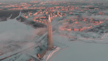 Rusya, St. Petersburg, 08 Ocak 2022: Kışın gün batımında Lakhta merkez gökdeleni, Gazprom şirketinin ofisinin gelecekteki ana binası, pembe renkli binalar