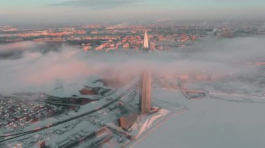 Rusya, St. Petersburg, 08 Ocak 2022: Lakhta merkez gökdeleninde gün batımında kış ayazında, geleceğin ana petrol şirketi Gazprom, insansız hava aracı sabit, bulutlar binanın üzerinde yüzüyor