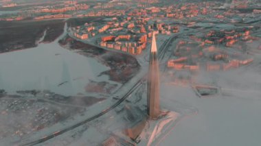 Rusya, St. Petersburg, 08 Ocak 2022: Güneş batarken Lakhta merkez gökdeleninde, Gazprom petrol şirketinin gelecekteki ana binası, binanın etrafında uçuşan insansız hava aracı