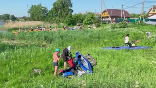 Russia, St. Petersburg, 08 June 2019: People are preparing to participate in a city rowing championship of kayaking, athletes prepare oars and life jackets, smear with sunscreen, sharing experiences — Stok video