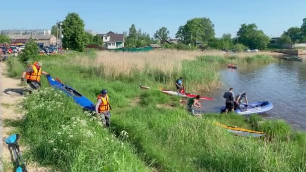 Russia, St. Petersburg, 08 June 2019: People are preparing to participate in a city rowing championship of kayaking, athletes prepare oars and life jackets, smear with sunscreen, sharing experiences — Stock Video