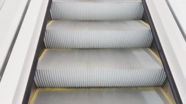 Boş modern yürüyen merdivenlerin, cam korkulukların yakın çekim görüntülerini ilk gören kişi.