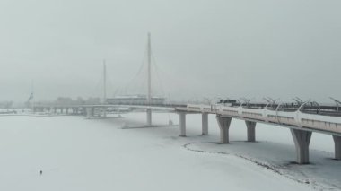 Rusya, St. Petersburg, 22 Ocak 2022: İnsansız hava aracı yeni Gazprom Arena stadyumuna giden kablo köprü boyunca uçuyor ve Zenit takımının bayrağı büyük bir bayrak direğinde sallanıyor
