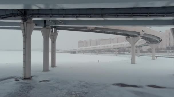 Безпілотник летить вздовж кабельного мосту в сніговий шторм, шосе, заметіль — стокове відео
