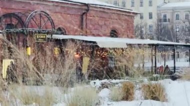 Rusya, St. Petersburg, 22 Ocak 2022: Karlı bir kış gününde Kuznya adasında bina, binaların gece aydınlanması, tuğlalardan duvar, kuru çimlerin arasından manzara