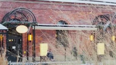 Rusya, St. Petersburg, 22 Ocak 2022: Karlı bir kış gününde Kuznya adasında bina, binaların gece aydınlanması, tuğlalardan duvar, kuru çimlerin arasından manzara