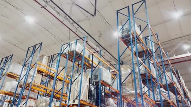 Bottom view footage of high shelving warehouse goods of logistics company, lots of light, large hangar, multi level storage — Stock Video